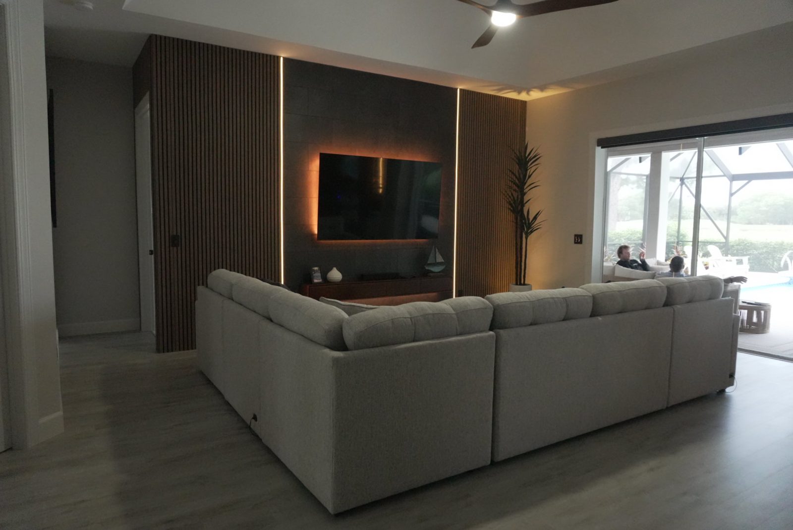 Custom wood-slat media wall with LED accent lighting in a Vero Beach living room