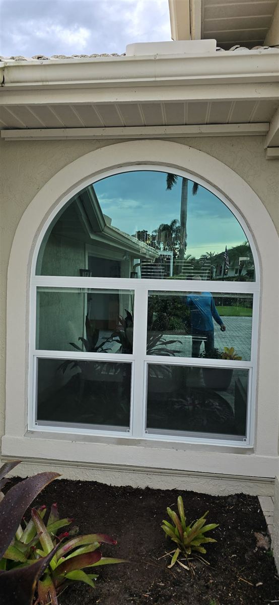 Arched impact window installation on a Florida home